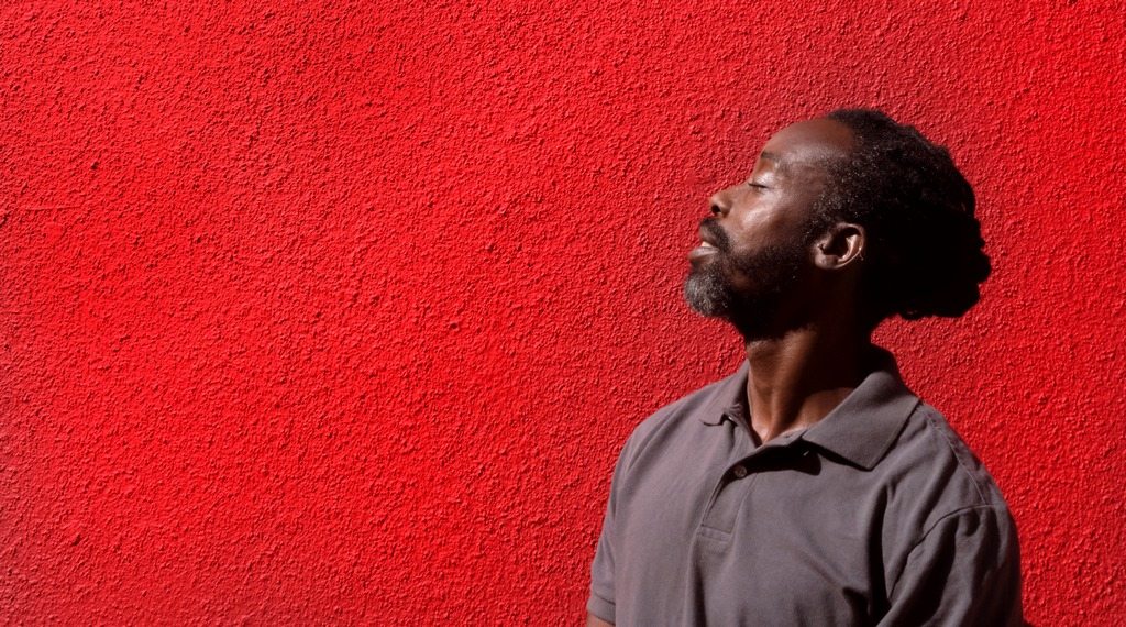 man breathing air in front of a wall